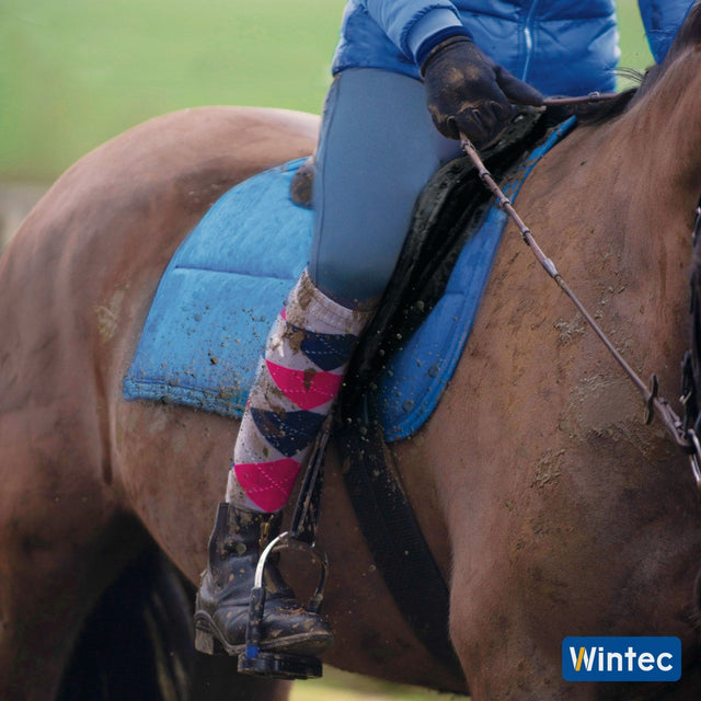 Close up of a rider's leg and a Wintec 500 All Purpose saddle on a muddy ride