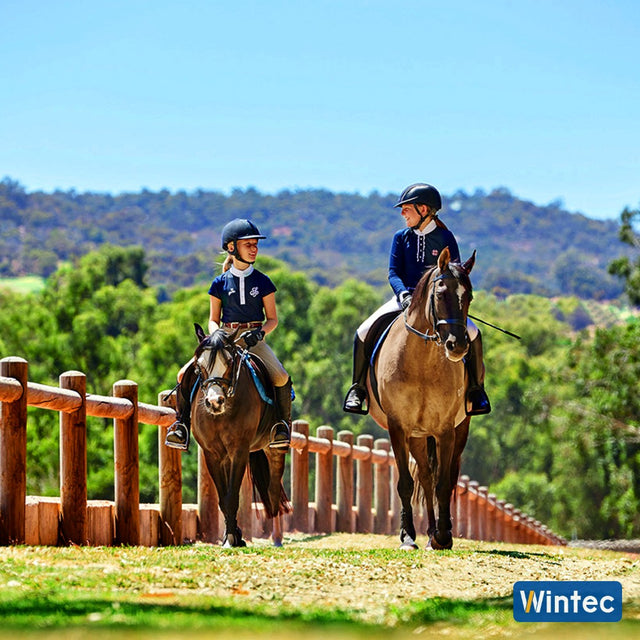 Two young riders hacking out on their ponies in Wintec saddles