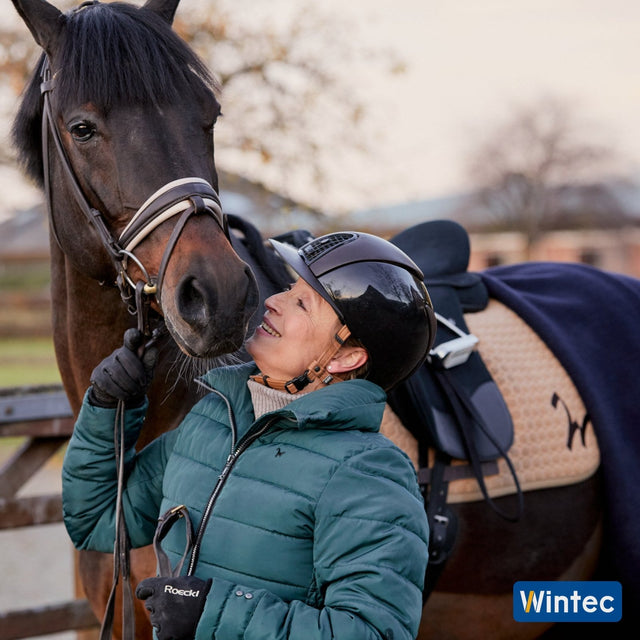 Rider greeting her horse, tacked up in the Wintec Isabell Icon