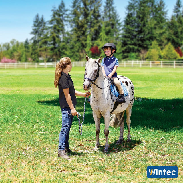 Young boy being led on a spotted pony in a Wintec Kids saddle